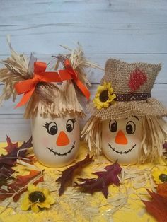 two painted pumpkins with scarecrow heads and sunflowers on them, sitting next to each other