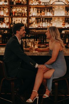 a man and woman sitting at a bar