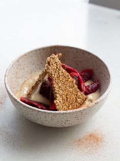 a white bowl filled with fruit and oatmeal on top of a table