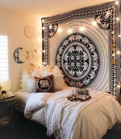 a bedroom decorated in black and white with lights on the headboard, bedding and pillows