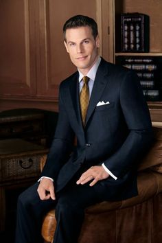 a man in a suit and tie sitting on a chair