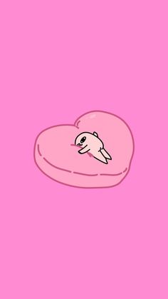 a pink heart shaped pillow with an animal on it