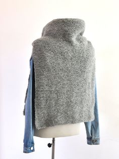 a gray and blue jacket on top of a white mannequin's head