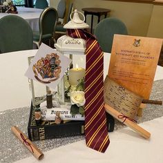 a table topped with books and harry potters tie next to an open book on top of a pile of books