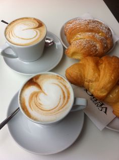 two cups of coffee and pastries on a table