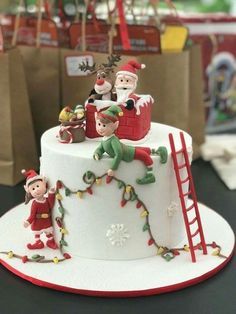 a christmas cake decorated with santa and elves