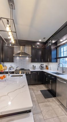 a kitchen with marble counter tops and stainless steel appliances, along with dark wood cabinets