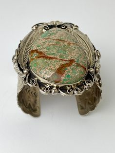 "Vintage Artisan Natural Sea Sediment Jasper Cuff Bracelet - Beautifully made by Navajo artist Percy Spencer - piece is signed - Substantial heavy rigid cuff - Navajo or coin silver, non-magnetic - Huge stone surrounded by very intricate silver work with feathers, flowers, swirls and stamp work on the arm cuff - The jasper stone is natural with lots of green, dark brown matrix and a tan colored background. Almost perfect teardrop shape. - Face of cuff measures 3.5\" x 2.5\" - Width of arm band 2 Bohemian Silver Cuff Bracelet With Patina, Silver Bohemian Cuff Bracelet With Patina, Artisan Collectible Cuff Jewelry, Unique Adjustable Inlay Cuff Bracelet, Bohemian Adjustable Untreated Bracelets, Bohemian Engraved Cuff Bracelet Collectible, Unique Collectible Cuff Bracelet, Southwestern Style Cuff Bracelet, Bohemian Patina Cuff Bracelet Collectible