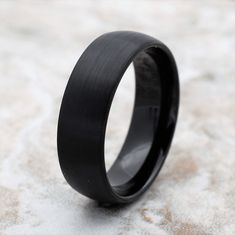 a black ring sitting on top of a stone floor