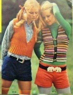 two women in shorts and sweaters standing next to each other