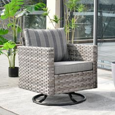 a chair sitting on top of a patio next to a potted plant