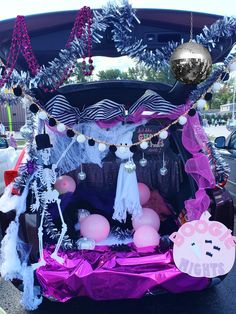 the trunk of a car decorated with balloons and decorations