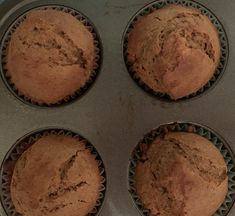 four muffins sitting in a pan on top of a counter