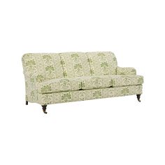 a green and white couch sitting on top of a wooden floor