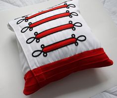 a red and white pillow with scissors on it