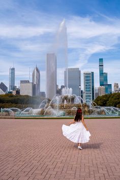 a woman is standing in front of a fountain