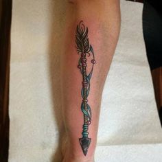 a person with a tattoo on their leg holding an arrow