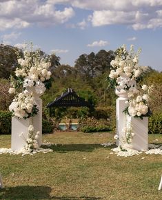 an outdoor ceremony setup with white flowers and greenery