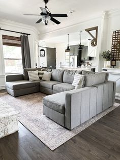 a living room filled with furniture and a ceiling fan