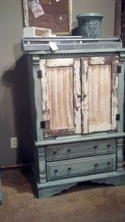 an old wooden cabinet sitting on top of a hard wood floor next to a wall