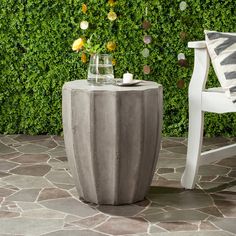 a white chair sitting next to a cement table