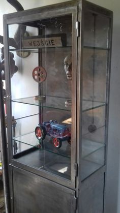 a display case with some toy cars in it's glass front doors and shelves