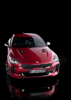 the front end of a red car on a black background