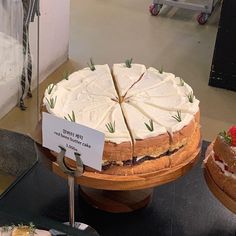 a cake with white frosting and strawberries is on display in a store window