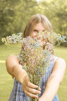 a woman is holding some flowers in her hands