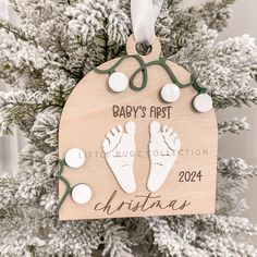 a baby's first christmas ornament hanging from a tree