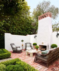 a patio with chairs, tables and a fire place