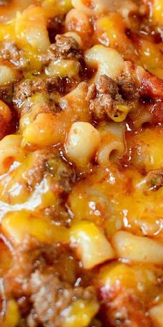 a close up view of some food in a pan with cheese and meat on it