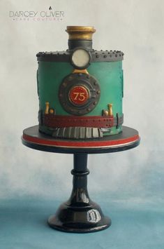 there is a cake that looks like a train engine on top of the cake stand