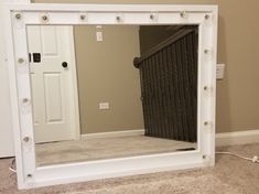 a mirror sitting on top of a carpeted floor in front of a white door