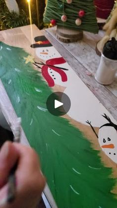 someone is painting a christmas scene on the table