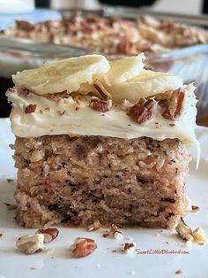 a close up of a piece of cake on a plate with nuts and banana slices