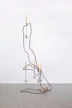 an artistic sculpture made out of wires and lightbulbs on top of a cement floor