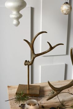 a candle holder with antlers on it next to a christmas tree ornament