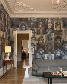 a living room filled with furniture and wallpaper covered in pictures