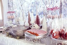 a table topped with lots of desserts covered in frosted icing and candy