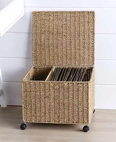 a wicker storage box with magazines in it sitting on the floor next to a radiator