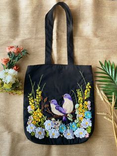 a black bag with flowers and a bird on it