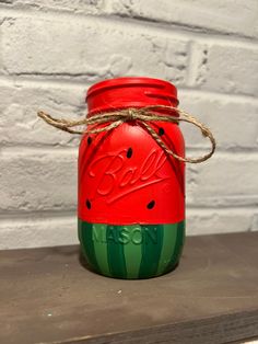 a red mason jar sitting on top of a wooden table