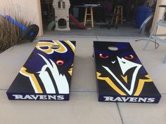 two baltimore ravens cornhole boards sitting on top of a cement floor in front of a building