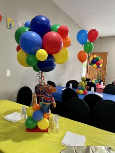 a table topped with lots of balloons in front of a room filled with tables and chairs