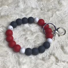 a red, white and grey beaded bracelet on a keychain