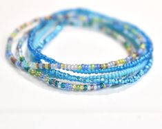 Ocean Vibes 11/0 Seed Bead Bracelet Set This listing is for all 5 bracelets shown. They are made with super tiny size 11/0 Czech seed beads. The beads are 1mm-2mm. They are made on clear stretch cord and a small clear knot shows. You will receive one of each of the colors shown.  These bracelets stretch and slide over your hand. It's best not to pull them too much, but instead put your hand in and slide or roll them into place on your wrist. Also, it's best to not get them wet. :) To determine y Blue Wrap Bracelet With Tiny Beads For Gift, Blue Stretch Bracelet With Tiny Beads For Beach, Blue Wrap Bracelet With Spacer Beads, Ocean-inspired Strand Beaded Bracelets For Beach, Blue Tiny Beads Stretch Bracelet For Beach, Blue Beach Bracelet With Tiny Beads, Blue Multi-strand Beaded Bracelets With Spacer Beads, Blue Multi-strand Bracelets With Spacer Beads, Blue Multi-strand Beaded Bracelets With Tiny Beads