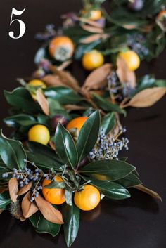 oranges and leaves are arranged on the table