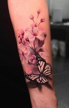 a woman's arm with a butterfly and flowers on it