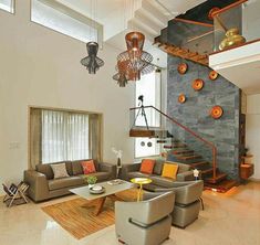 a living room filled with furniture next to a stair case